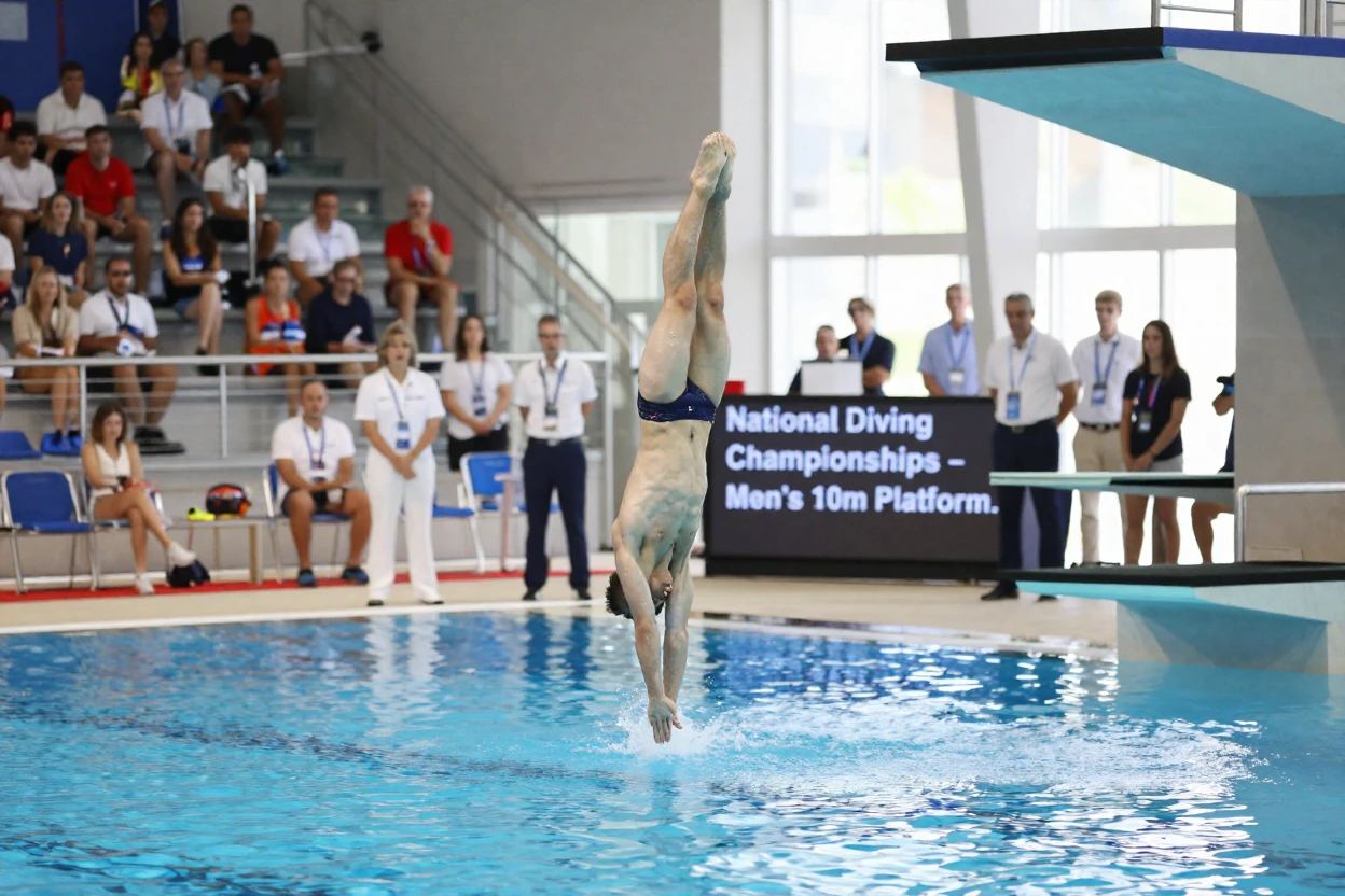 A diver enters the water with barely a splash during a competition.
