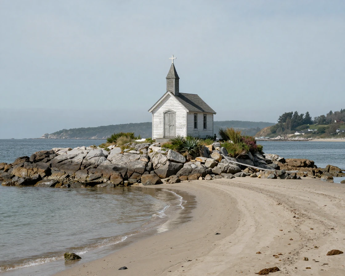 A tiny chapel sits alone on a rocky island connected to shore by a thin sandbar at low tide.