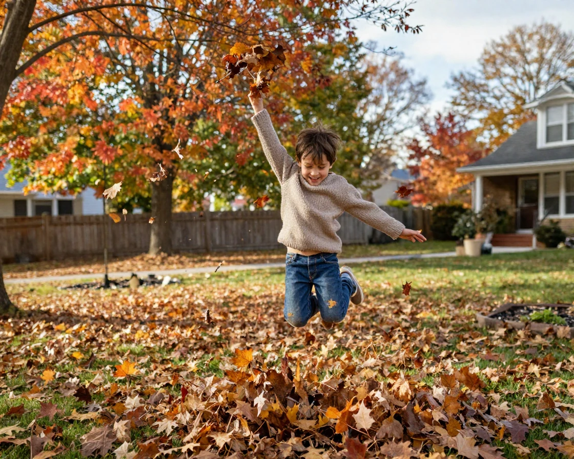 Autumn leaves swirl around a child jumping into a raked pile in a suburban yard.